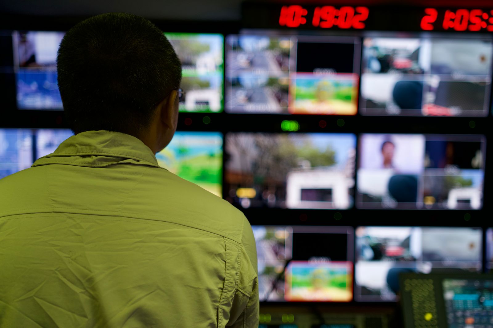 Operador acompanhando vários monitores em uma central de controle